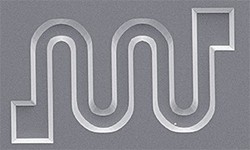 Fig. 1: Scanning electron microscopy image of a curved microfluidic channel formed on a silicon surface by adding surfactant molecules to a wet etchant solution.