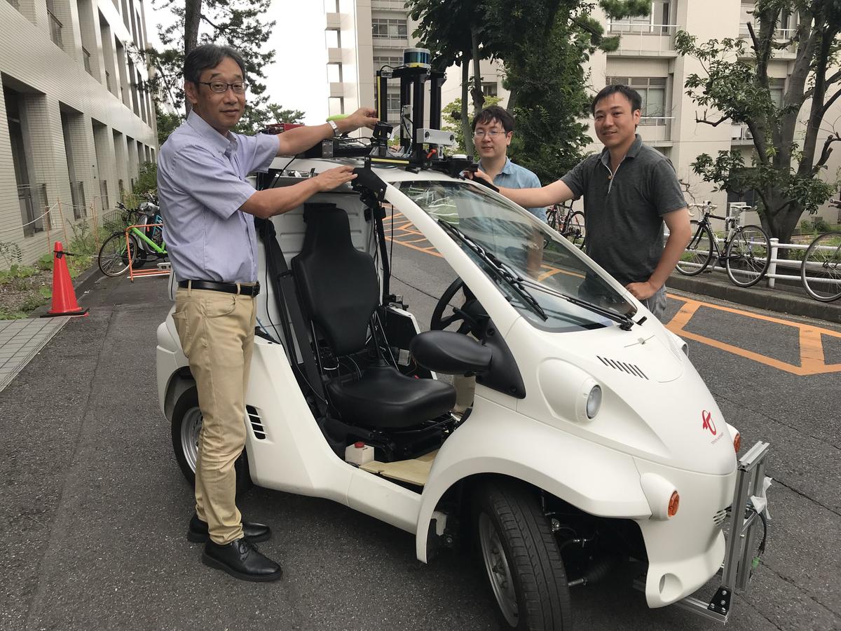 Professor Tatsuya Suzuki (left) and an electric autonomous vehicle being researched