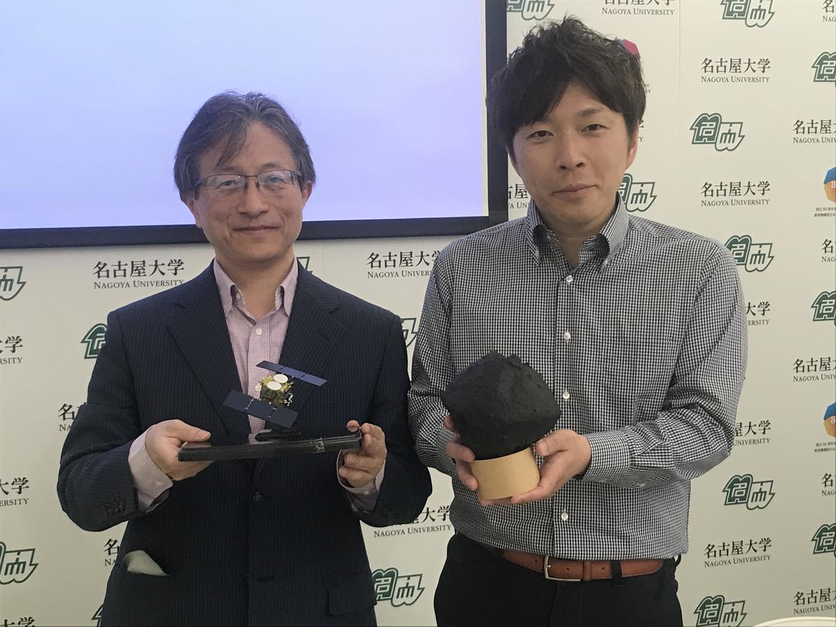 Professor Sei-ichiro Watanabe (Left) holding a model of Hayabusa2, and lecturer Tomokatsu Morota (now Associate Professor, the University of Tokyo) holding a model of Ryugu.
