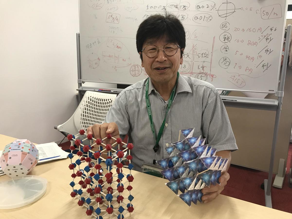 Designated Professor Shoichi Onda talks with crystal models in hand.