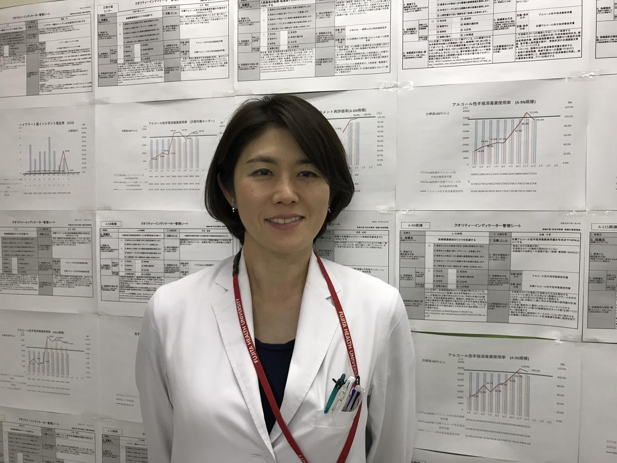 Prof. Ayuko Yasuda stands before an array of data for visualizing processes