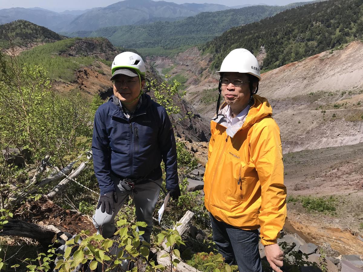 With the Ontake collapse visible behind them, this is Prof. Koshun Yamaoka (right) from the Earthquake and Volcano Research Center, and Takahiro Kunitomo, Designated Associate Professor at the Mount Ontake Volcano Research Facility.