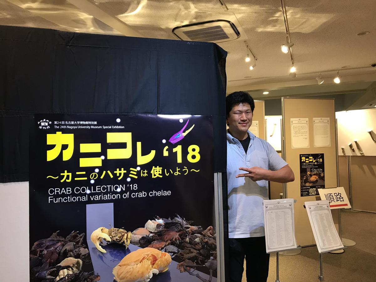Lecturer Shin-ichi Fujiwara stands at the entrance of Crab Collection '18. In the poster, both the models who “crab walk” down the runway of the fashion show and the audience are crabs.