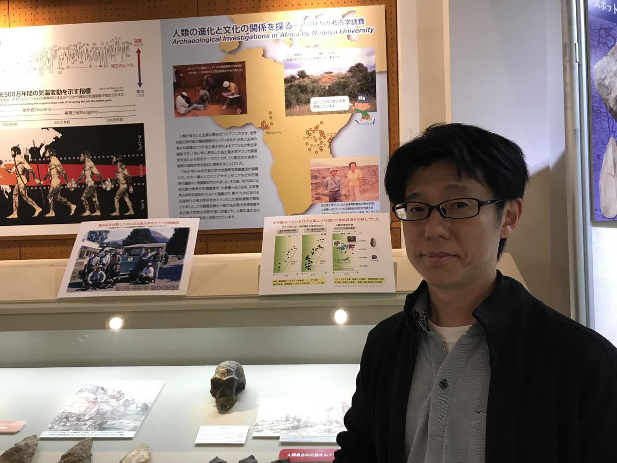 Lecturer Seiji Kadowaki stands in the human evolution corner of the permanent exhibition, where a collection of stone implements are displayed.