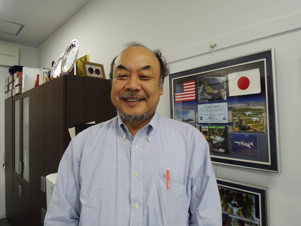 Designated Professor Takashi Ishikawa, standing in front of a Certificate of Appreciation from his research partner, the US National Aeronautics and Space Administration (NASA)