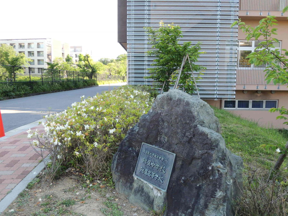 The affiliate schools have no exterior gates, only a stone marker in front of the school building. Nagoya University's School of Engineering can be seen on the left in the background.