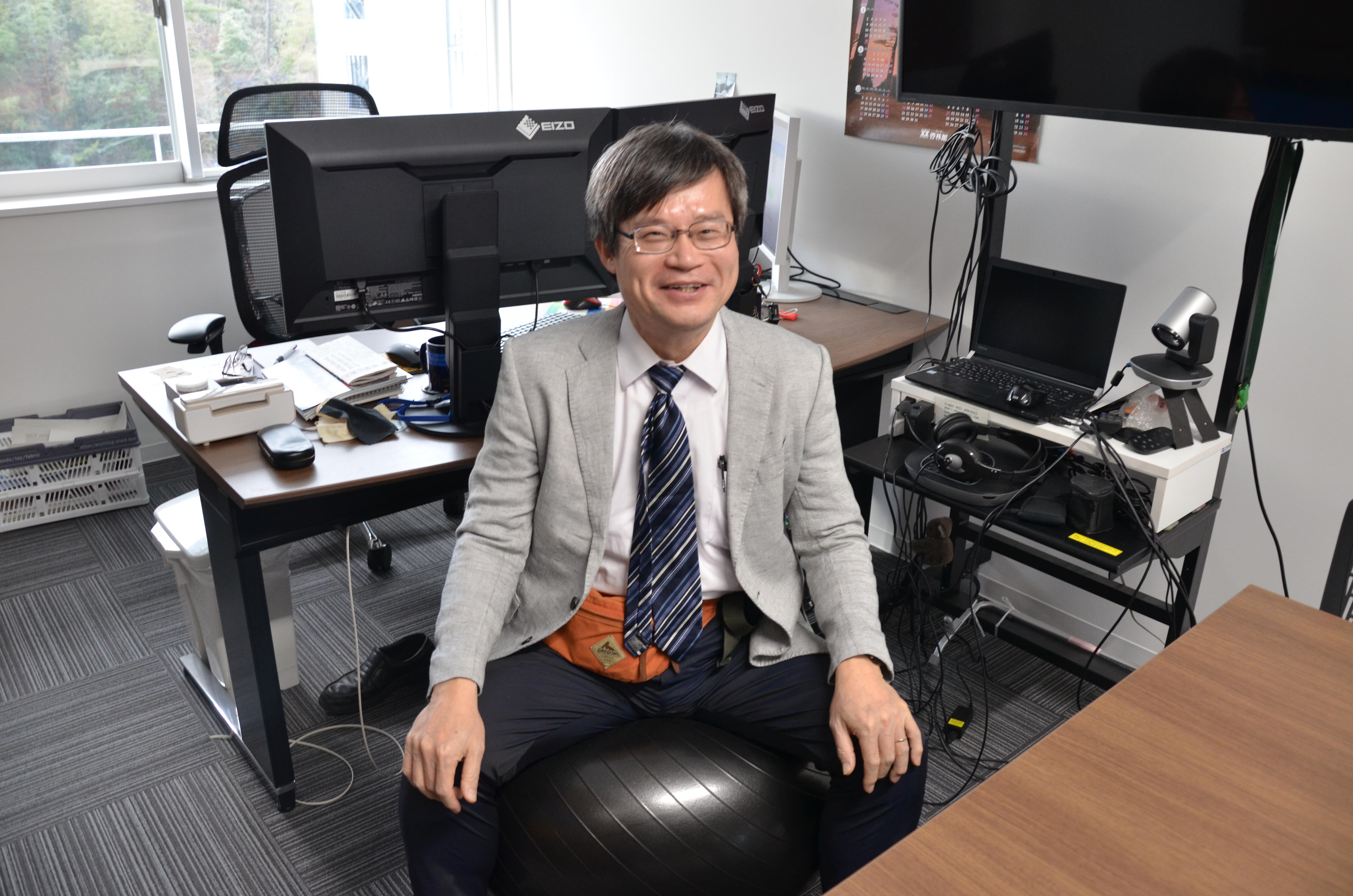 Sitting on a balance ball in his laboratory