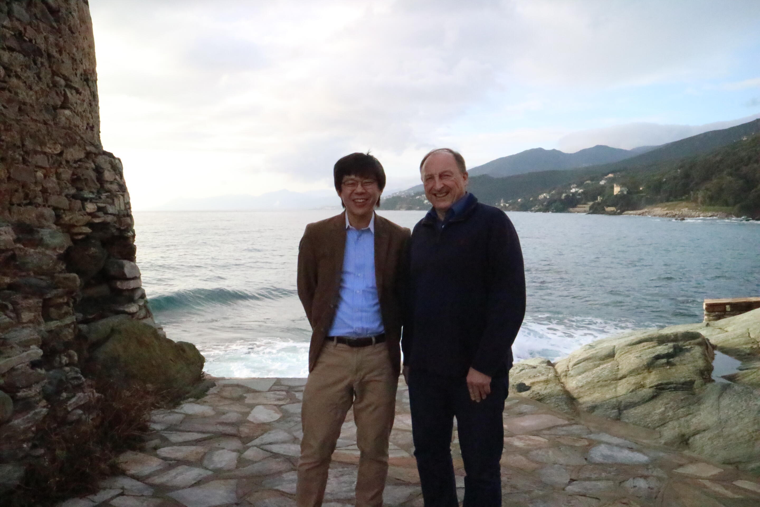Dr. Furuhashi (left) with symposium organizer Prof. Patrick Martin, by the seashore near the venue of a symposium in Bastia on Corsican Island, France (January 2020)