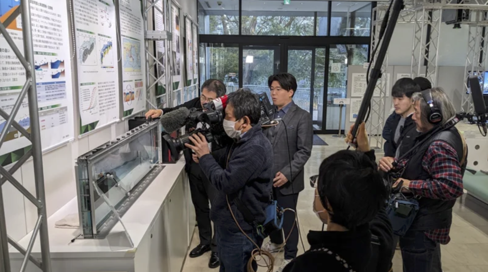 Earthquake simulator BiCURI recreating the movement of the Noto earthquake (above) and a TV crew filming a report on the Disaster Mitigation Research Building (below)