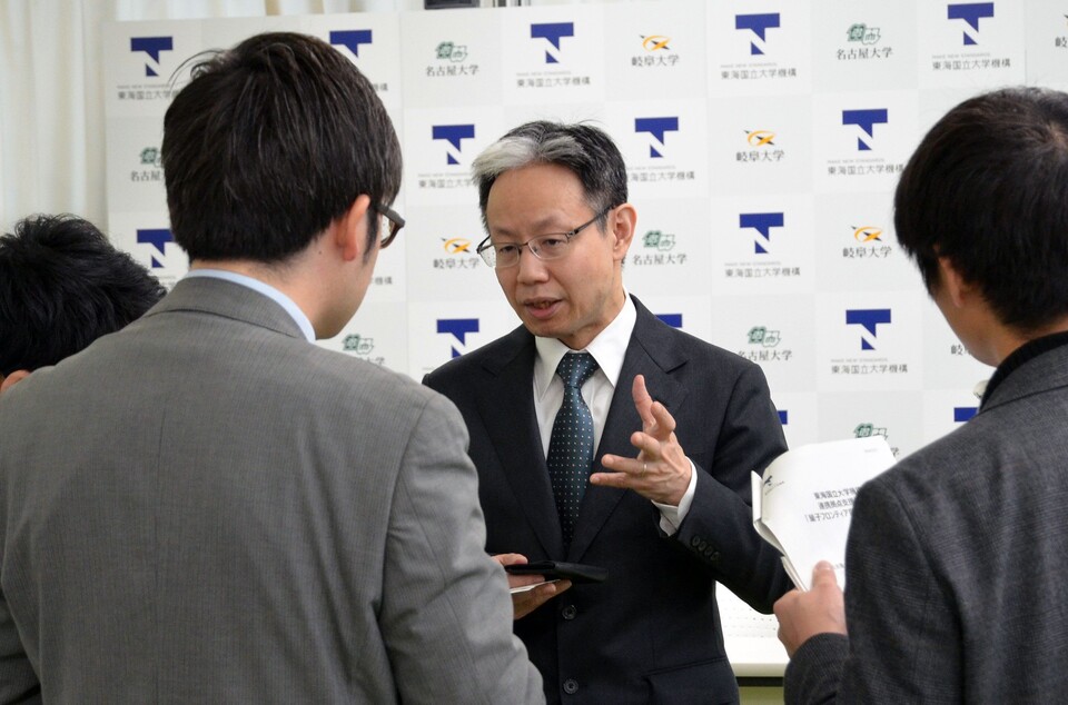 Professor Kiyonaka surrounded by reporters discussing the hub's initiatives.