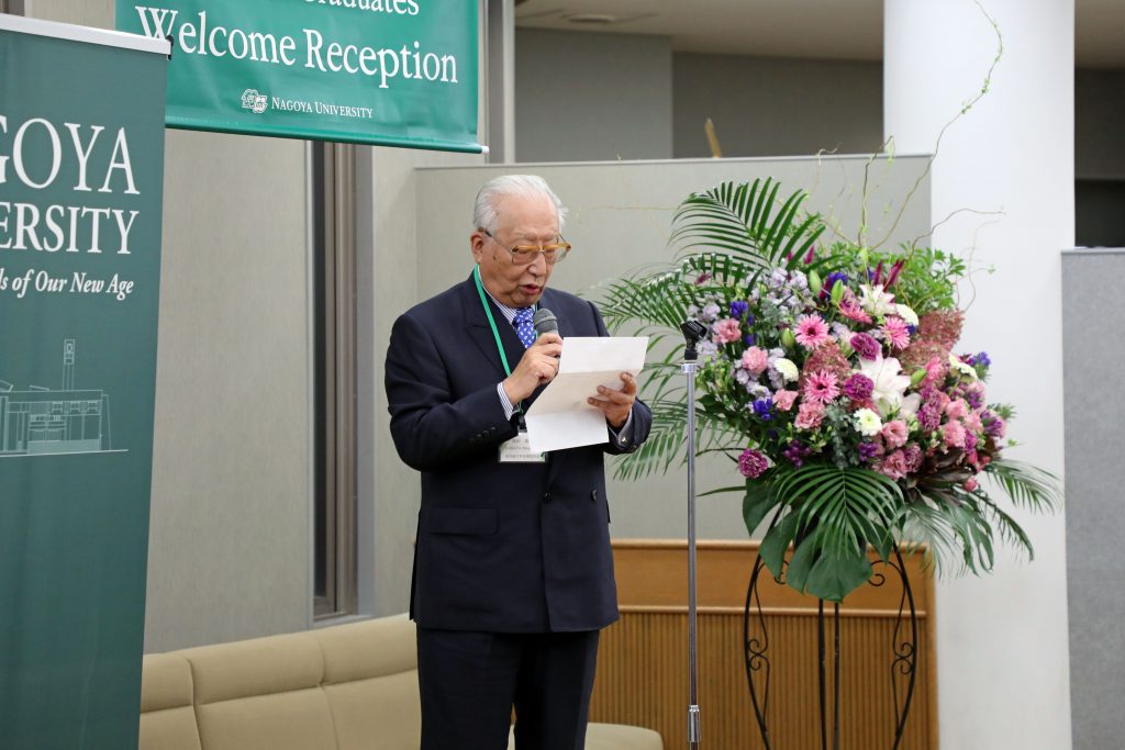 Nagoya University Alumni Association President Masaharu Shibata stands on stage and addresses the group