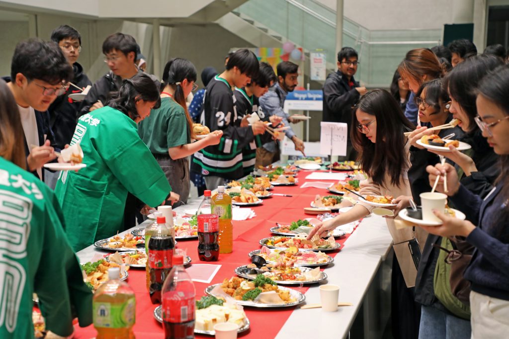 Students crowd around the tables to enjoy the food