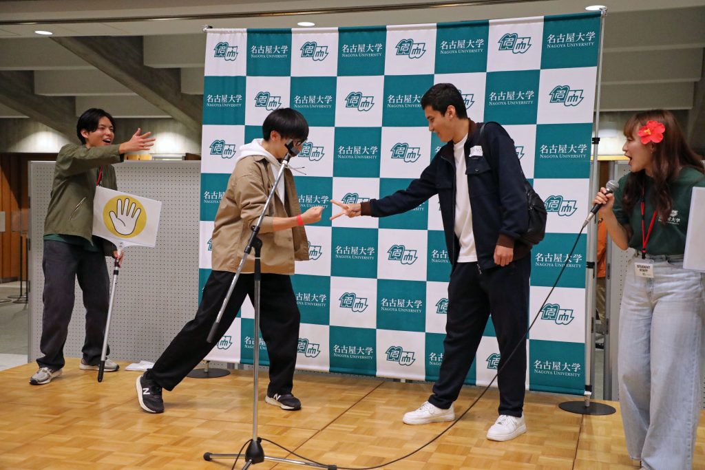 Two students face each other on stage in the finals of the rock-paper-scissors competition