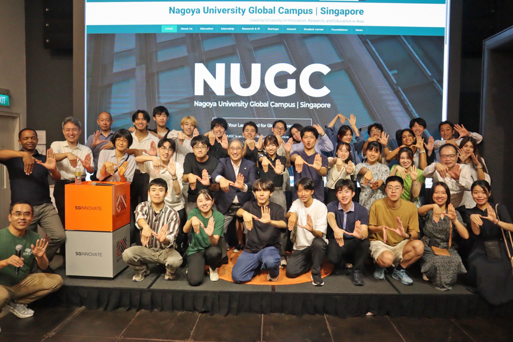 Group of students and President Sugiyama on stage in Singapore