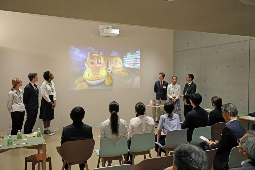 Students from St John's College stand and present a photo slideshow about their time in Japan.