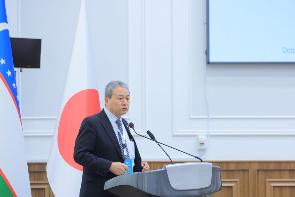 Nagoya University Vice President Norimi Mizutani stands at a podium and explains Nagoya University's initiatives.