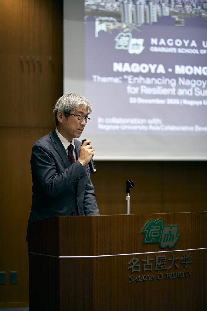 Deput Director Nishimura speaking at podium