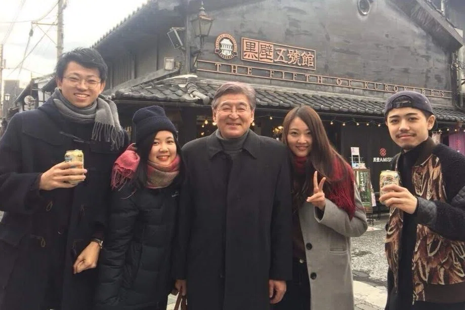Professor Machida and four students stand in front to a building during a research trip.