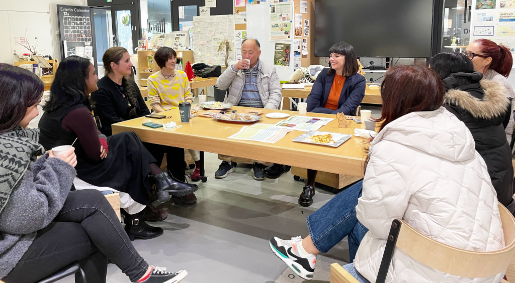 A group of nine researchers and faculty members sit around a rectangular tables during one of the NODES meetings