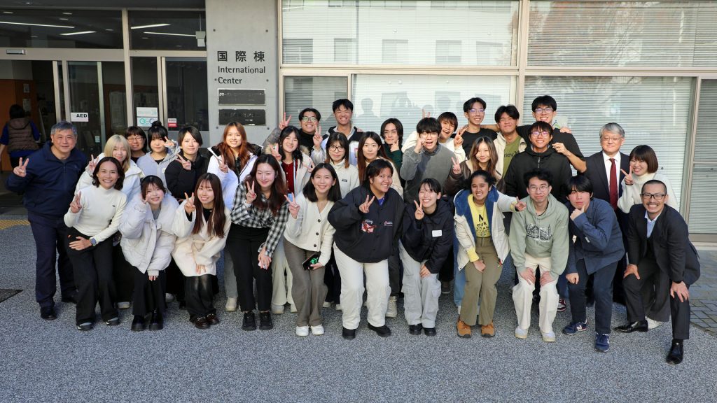 Students and faculty members from Nagoya University and National University of Singapore stand in rows for a group photo at the end of the exchange program.