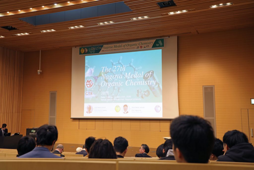 A presentation showing the name of the event and this year's winners is projected on a screen on stage.