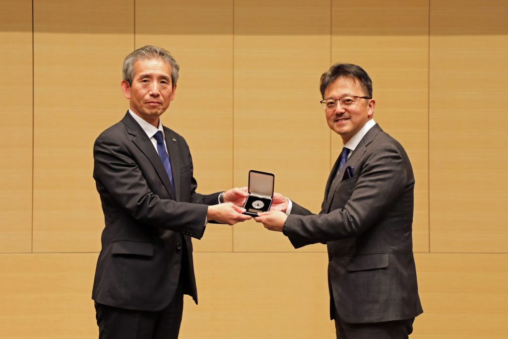 Professor Hajime Ito receives his medal on stage.