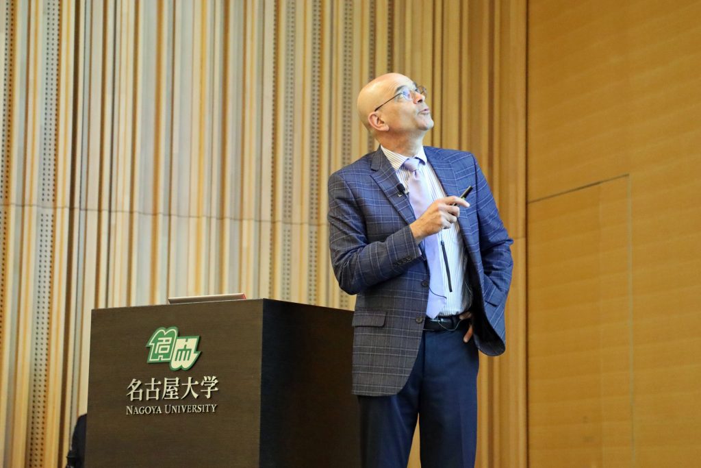 Professor Erick M. Carreira stands near a podium, giving one of his lectures during the event.