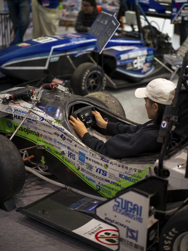 An attendee sits in the formula car.