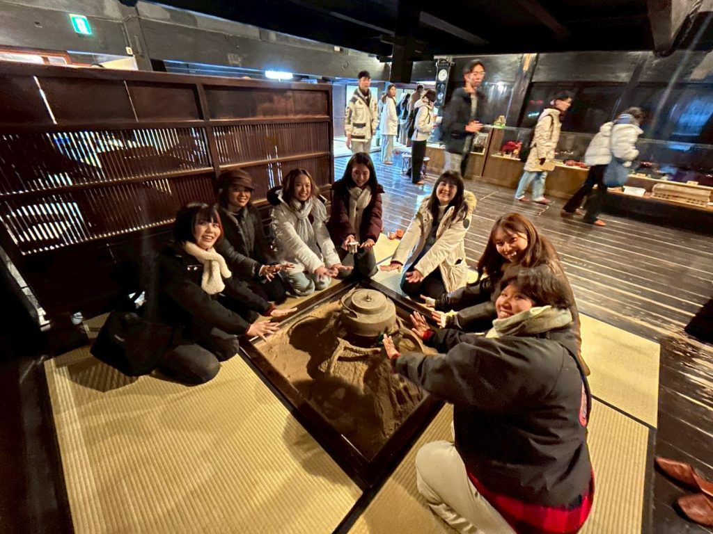 Sevens students sit around a traditional hearth.