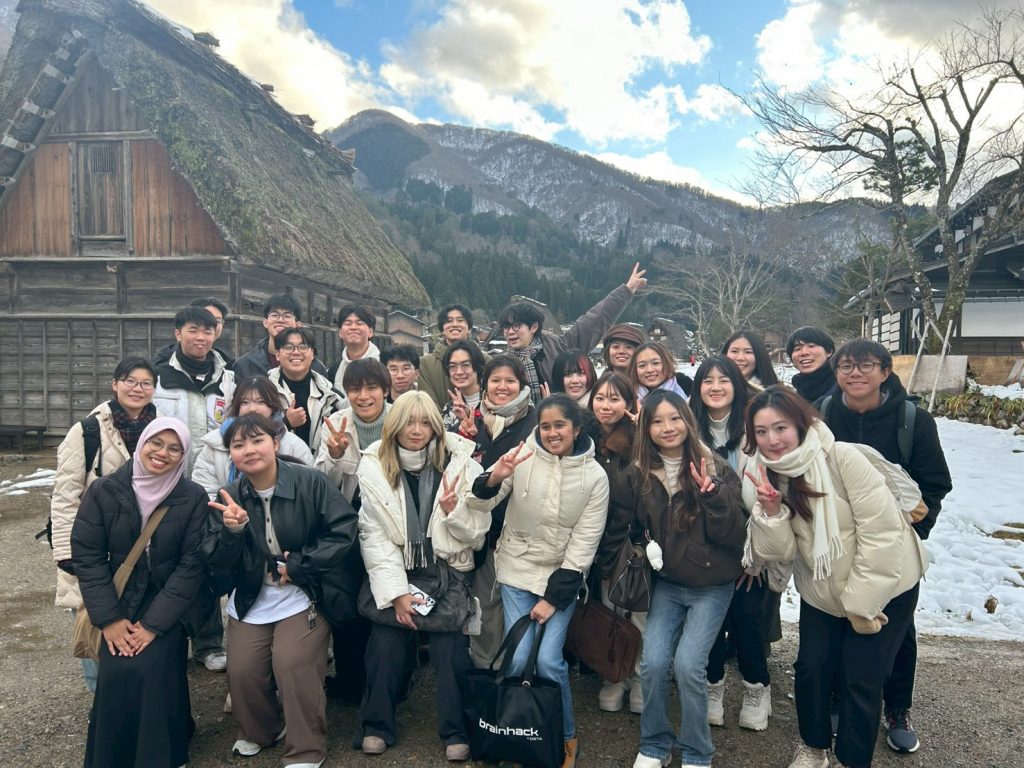 Students pose for a group photo in from the the traditional houses of Shirakawa-go.