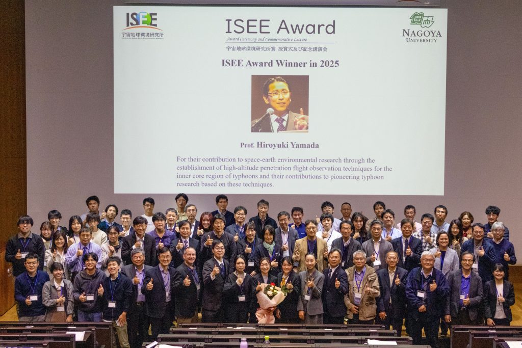 Participants stand in rows on stage for a group photo.