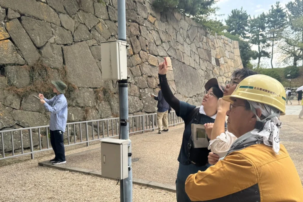 A group of students inspect one of the stone walls with the help of an expert.