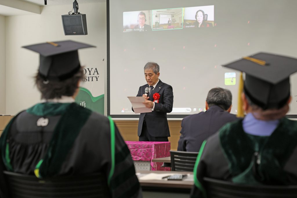 Naoshi Sugiyama stands at the front of the room and gives his congratulatory remarks.
