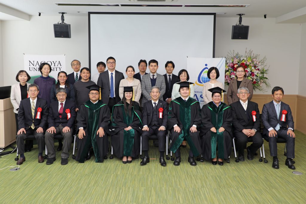 The graduates and all attendees gather at the front of the room for a group photograph.