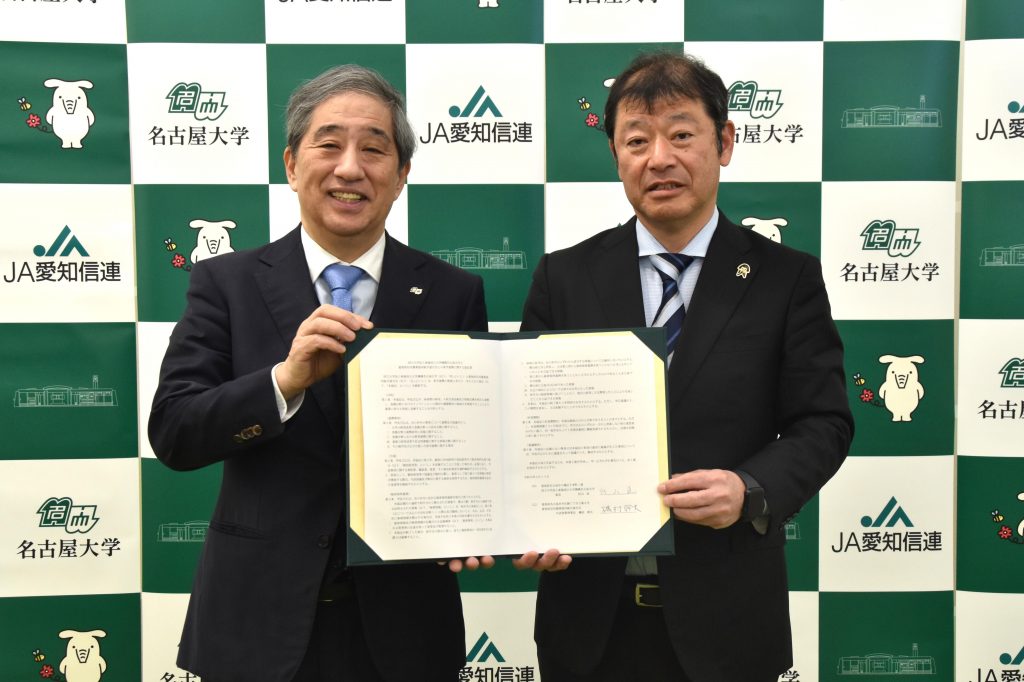 President Naoshi Sugiyama of Nagoya University (left) and Chairman Mikio Isomura of JA Aichi Shinren (right) hold up a contract.