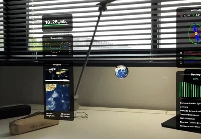 An in-app screenshot of Ishiwatari's app. A graphic of the earth and various graphs are superimposed onto a camera view of a desk.
