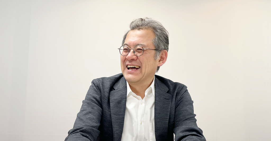 Toru Ujihara smiling during an interview with Masahiro Kito.