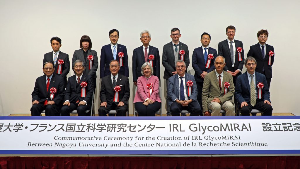 The guests of honor gather on the stage in two rows for a group photo.