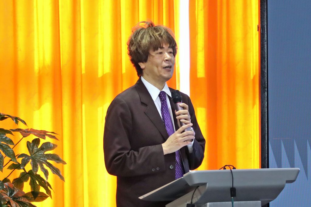 Vice Dean Tetsuki Tamura stands at a podium on stage and gives his remarks.