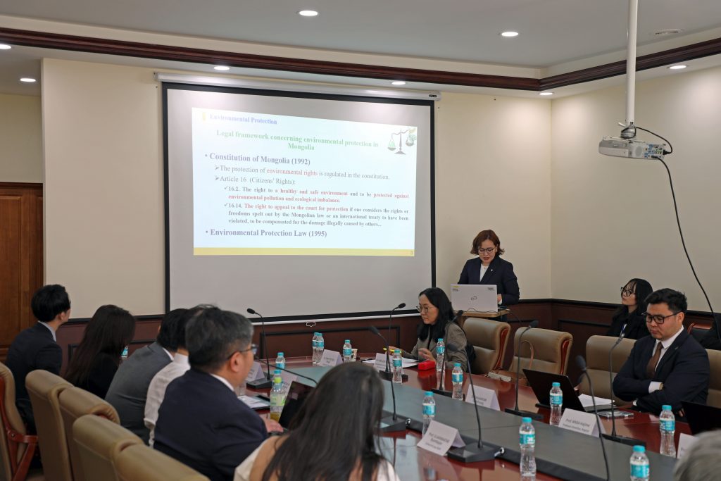 Designated Assistant Professor Molom Sukhbaatar stands at a podium in a conference room, presenting her research.