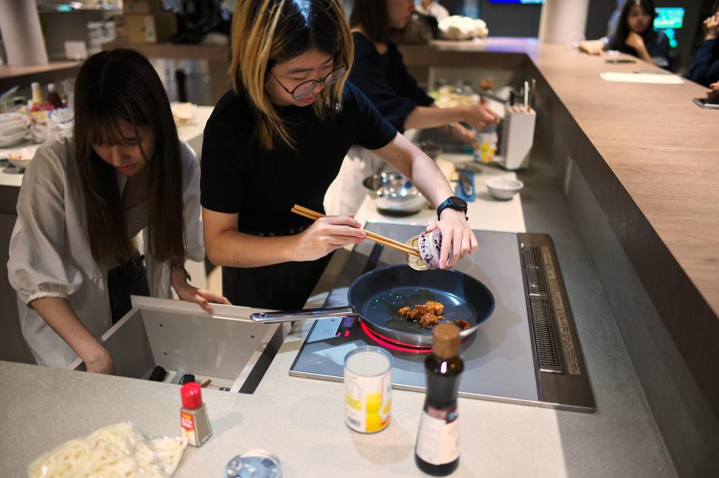 Student heats up canned yakitori in a pan
