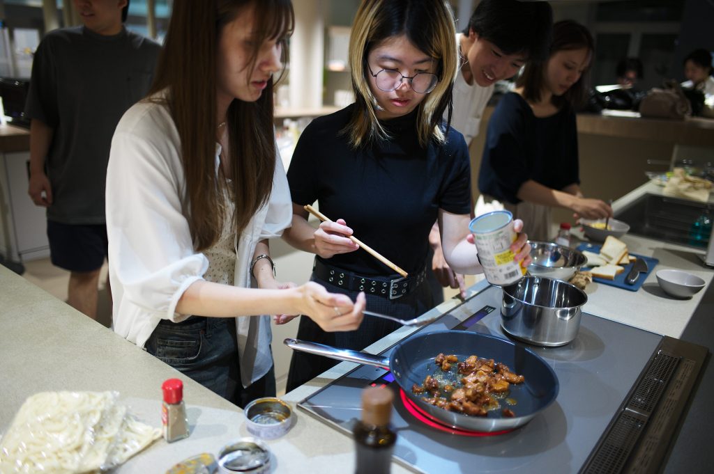 Students heat up canned yakitori in a pan