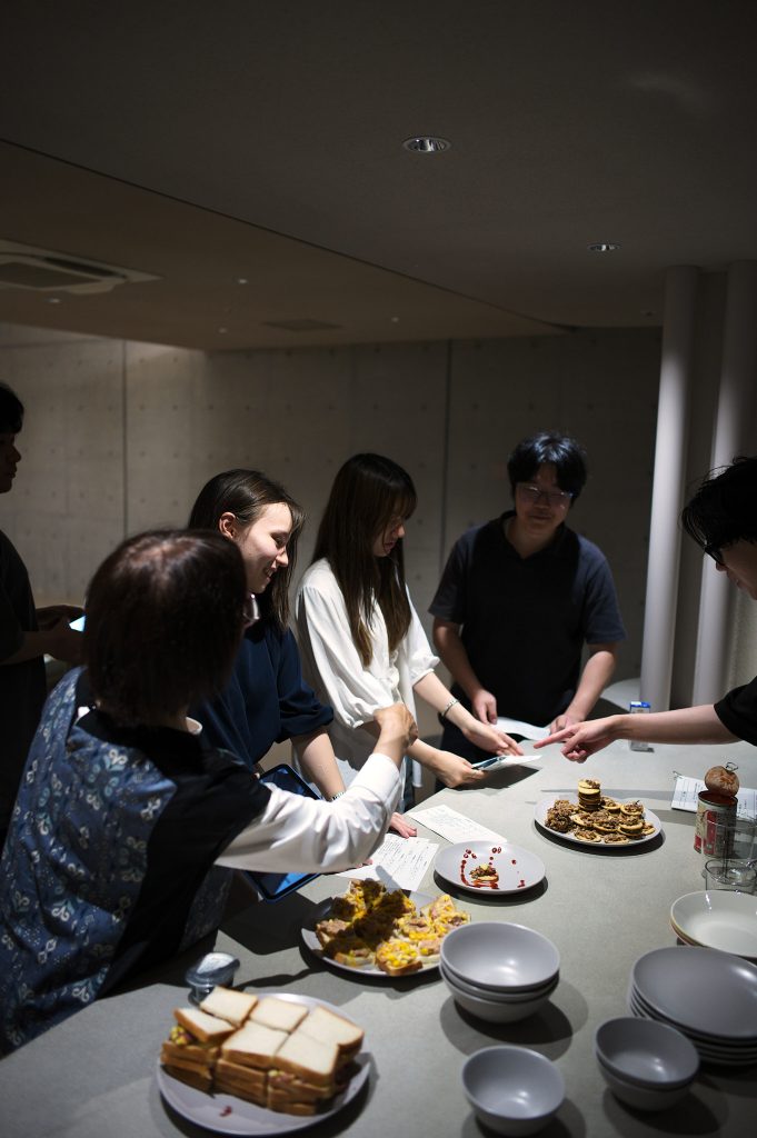 Students standing around the prepared food counter judging the dishes