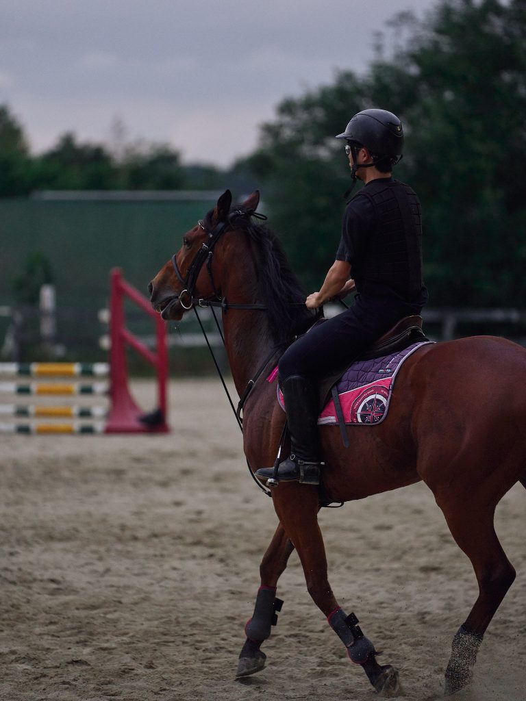 A student rides a club horse during warmup