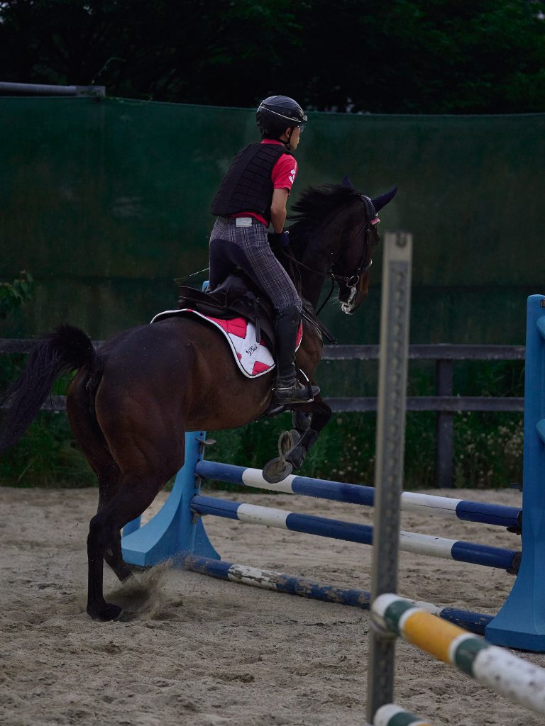 Student jumps a horse over the hurdle