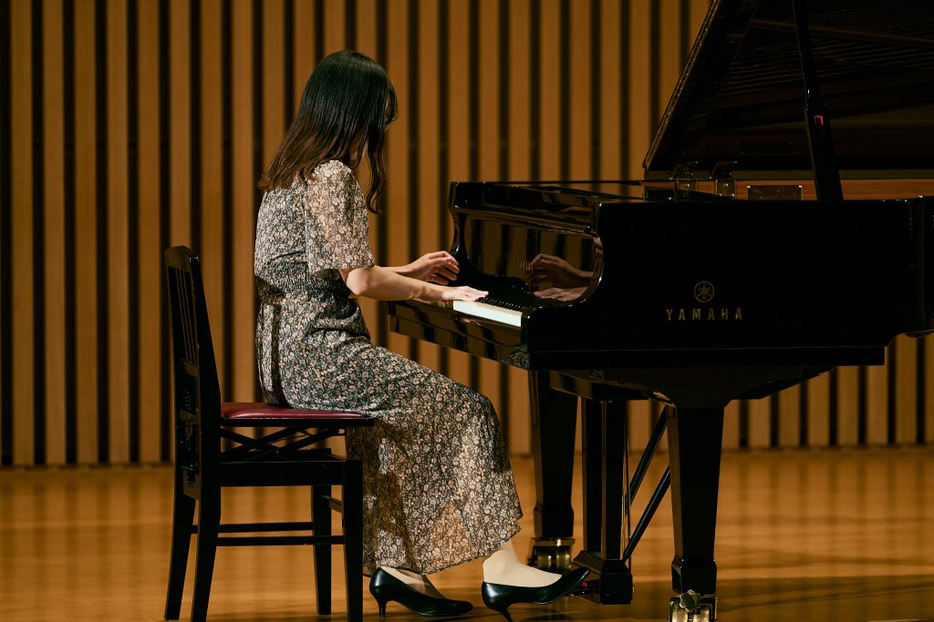 Student plays a piano on stage in the Toyoda Auditorium during the Nagoya University Festival
